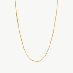 14K solid yellow gold snake chain necklace featuring a sleek, herringbone design. This minimalist and elegant chain offers a smooth, fluid texture, perfect for layering or wearing as a statement piece for everyday sophistication.