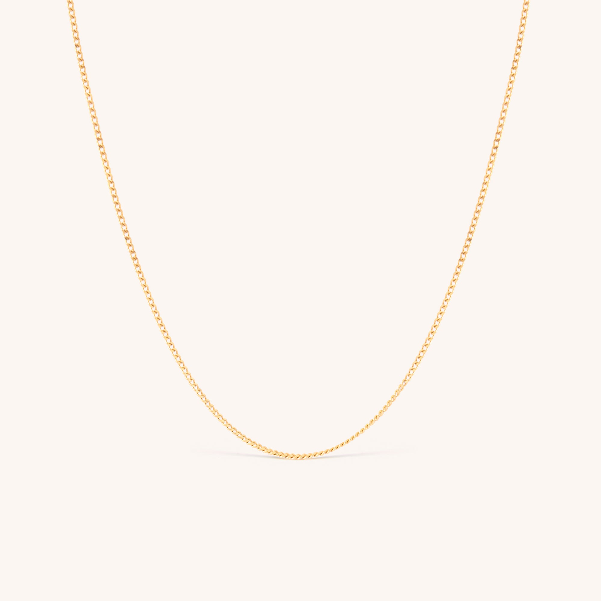 14K solid yellow gold dainty curb chain necklace with a minimalist design, featuring delicate Cuban links. Perfect for layering or wearing solo, this timeless gold chain adds elegance to any look, ideal for daily wear or special occasions.