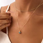 Blue heart evil eye necklace in 14K yellow gold. A dainty protective charm necklace with a modern design, ideal for adding a touch of luck and style to any outfit.