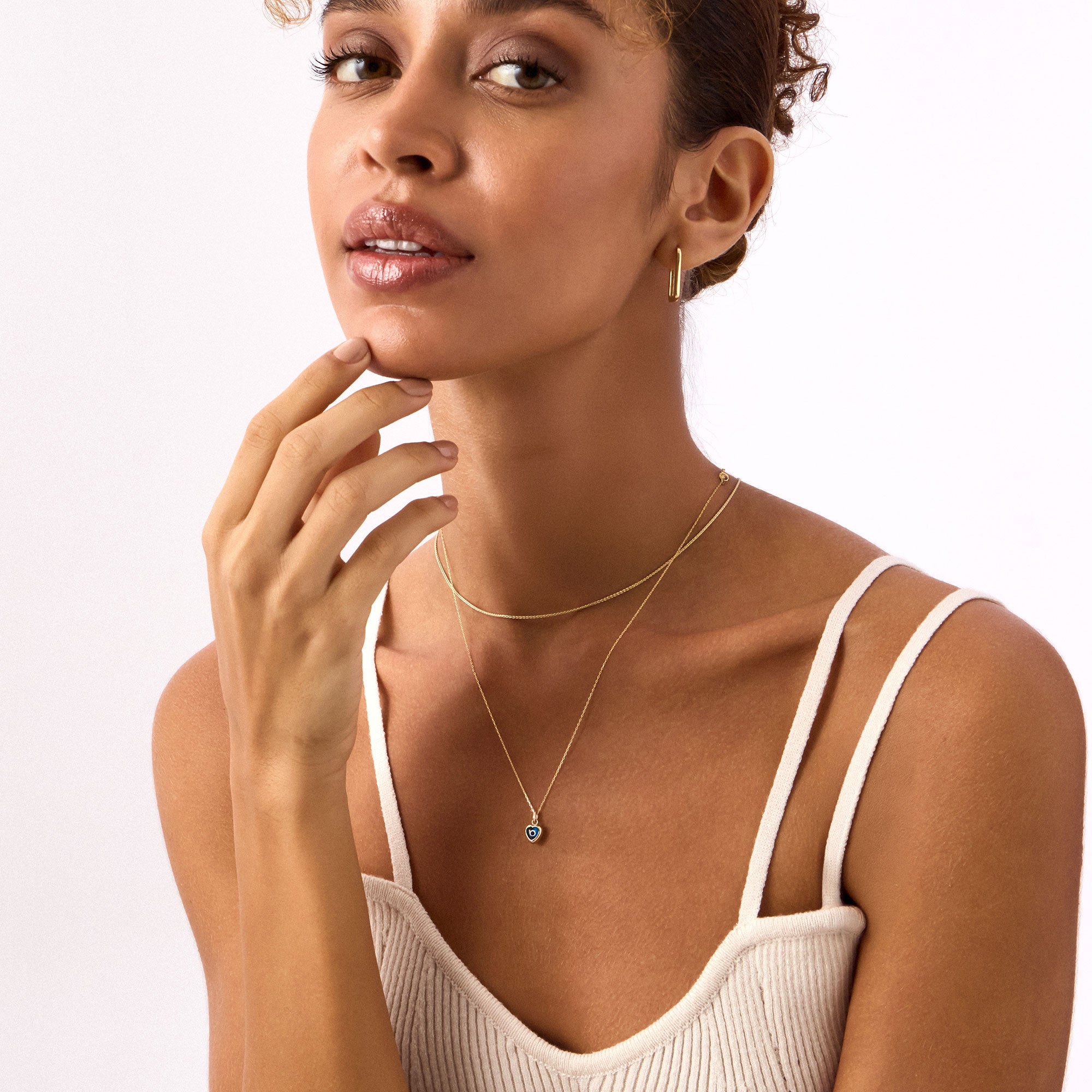 Blue heart evil eye necklace in 14K yellow gold. A dainty protective charm necklace with a modern design, ideal for adding a touch of luck and style to any outfit.