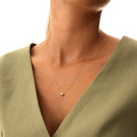 Simple and chic 14K solid gold floating bead necklace. This minimalist design showcases a single gold sphere, adding a touch of elegance to any look.