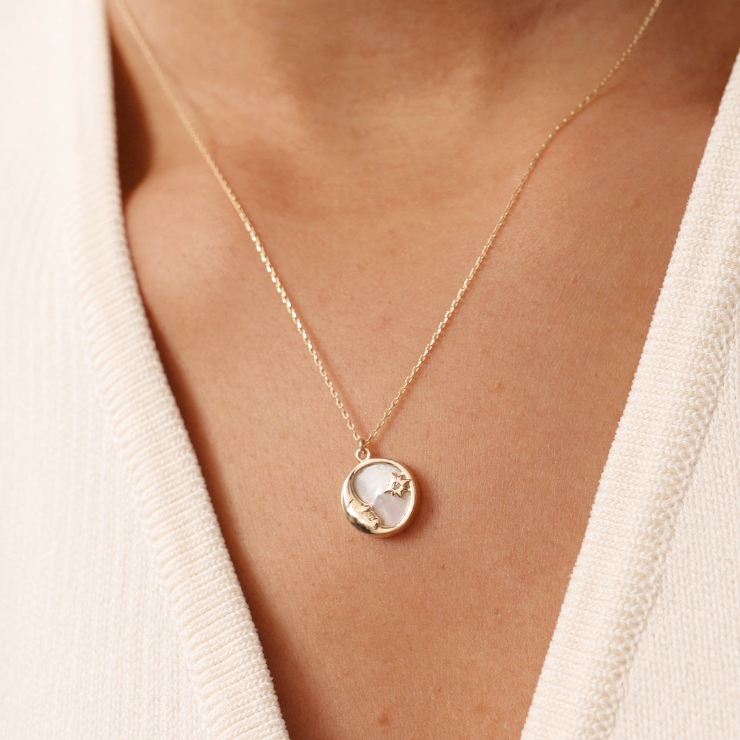 Delicate 14K yellow gold necklace with a round pendant showcasing a crescent moon and star, accented with mother of pearl. A celestial-inspired design, ideal for lovers of minimalist and symbolic jewelry, perfect for daily wear or as a special gift.