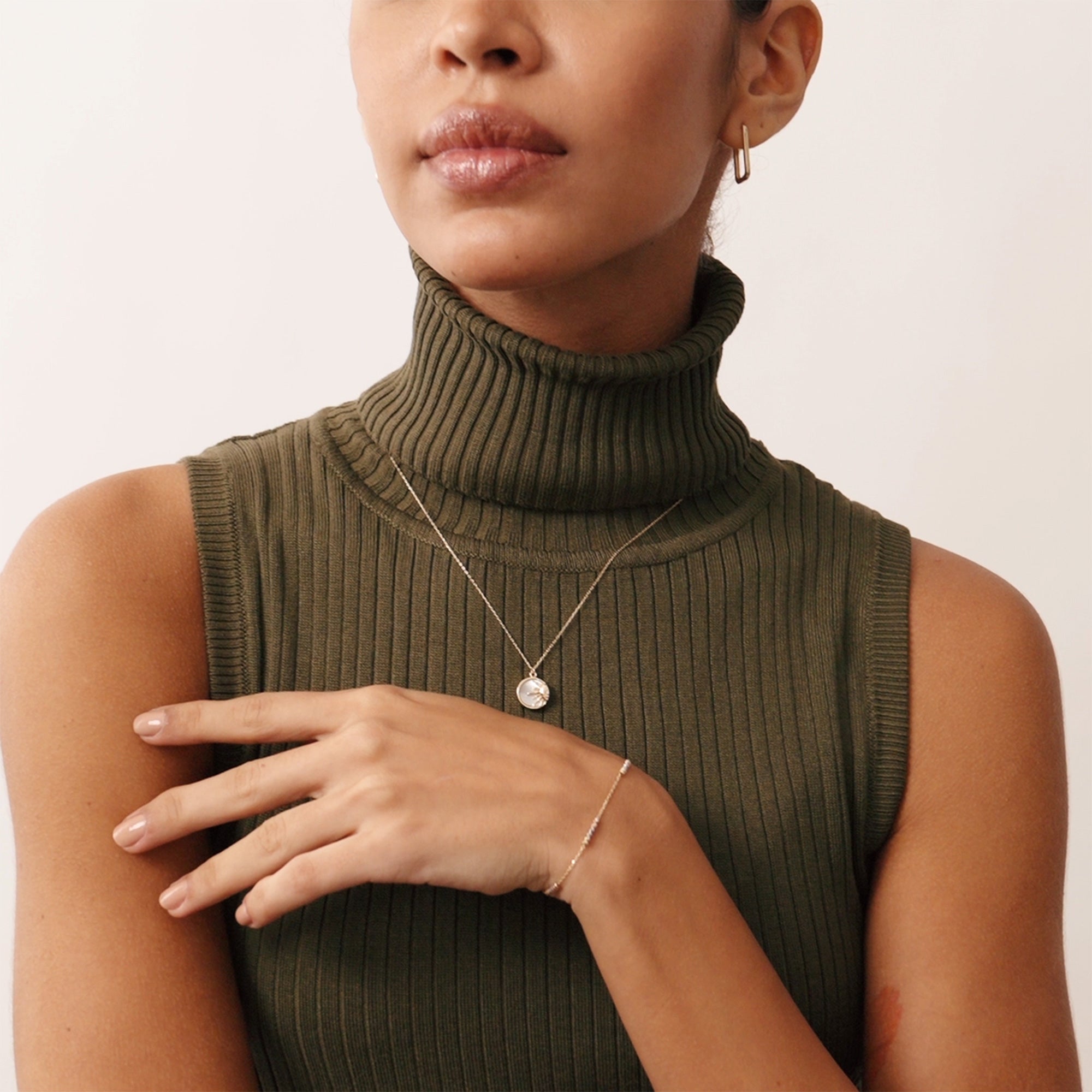 Delicate 14K yellow gold necklace showcasing a sun pendant with intricate rays and a mother of pearl background. This celestial-inspired necklace represents vitality and energy, making it a timeless and elegant accessory.