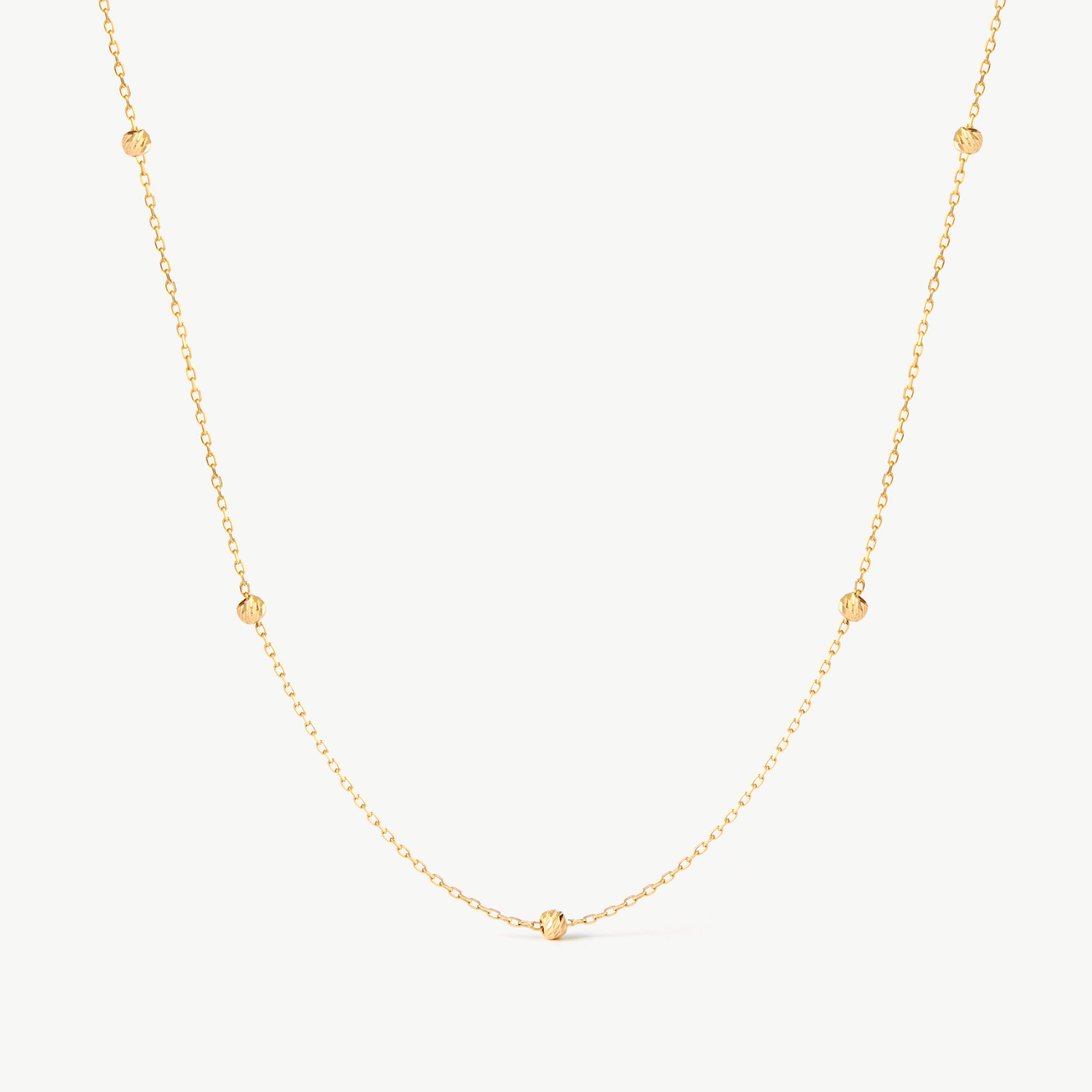 14K solid yellow gold beaded satellite chain necklace featuring small, evenly spaced textured beads. This minimalist and dainty necklace offers a delicate design, perfect for layering or as an elegant everyday accessory.