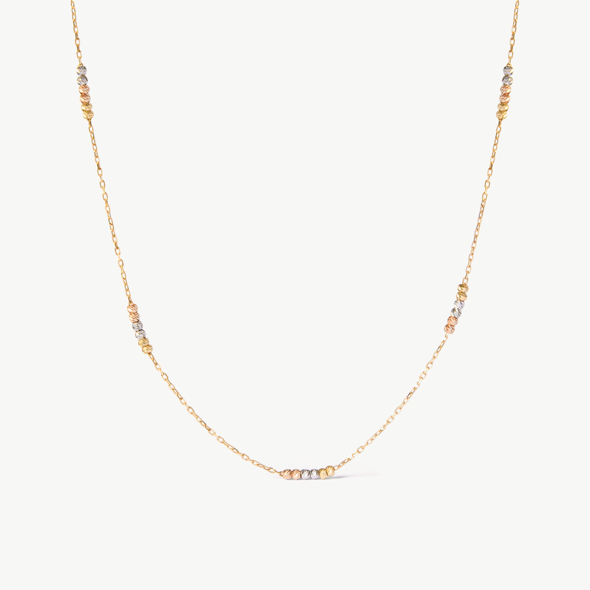 14K solid gold tricolor beaded station necklace featuring delicate yellow, rose, and white gold beads along a minimalist chain. This dainty and elegant piece is perfect for layering or wearing alone, offering a versatile and sophisticated look for any occasion.
