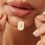 14K Real Solid Gold Initial Tag Necklace featuring a customizable rectangular pendant engraved with an initial, shown on a woman’s neck. A delicate, personalized gold bar necklace perfect for gifts and layering.