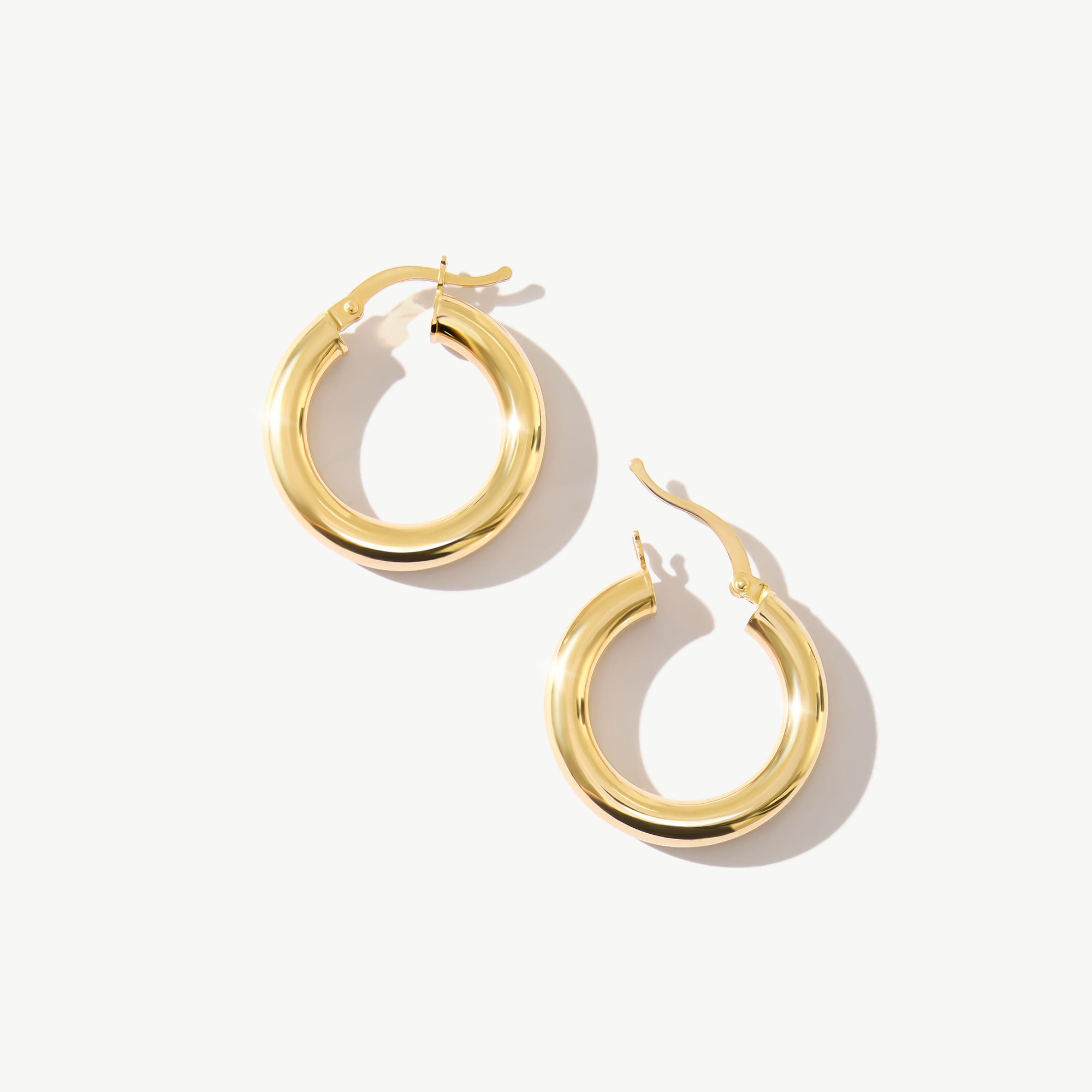 14K real solid yellow gold huggie hoop earrings with a minimalist design. These small, dainty hoops offer a sleek and elegant look, perfect for everyday wear or adding a subtle touch of sophistication to any outfit.