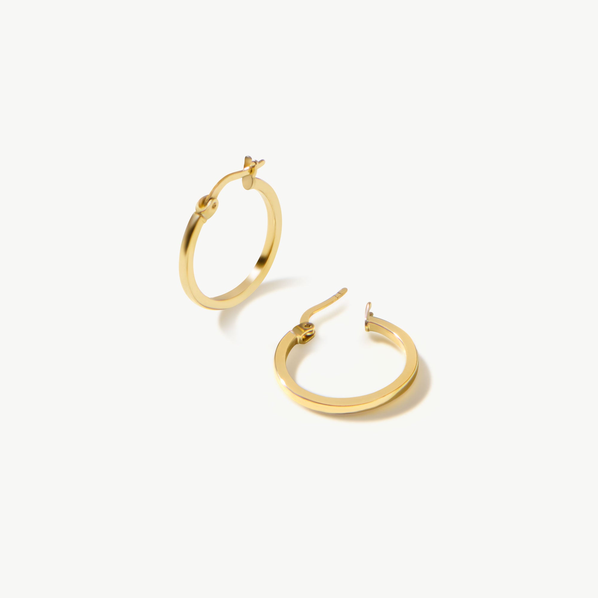 14K real solid yellow gold huggie hoop earrings featuring a sleek and minimalist design. These small, medium-sized hoops offer a polished and refined look, perfect for everyday wear or layering with other jewelry.