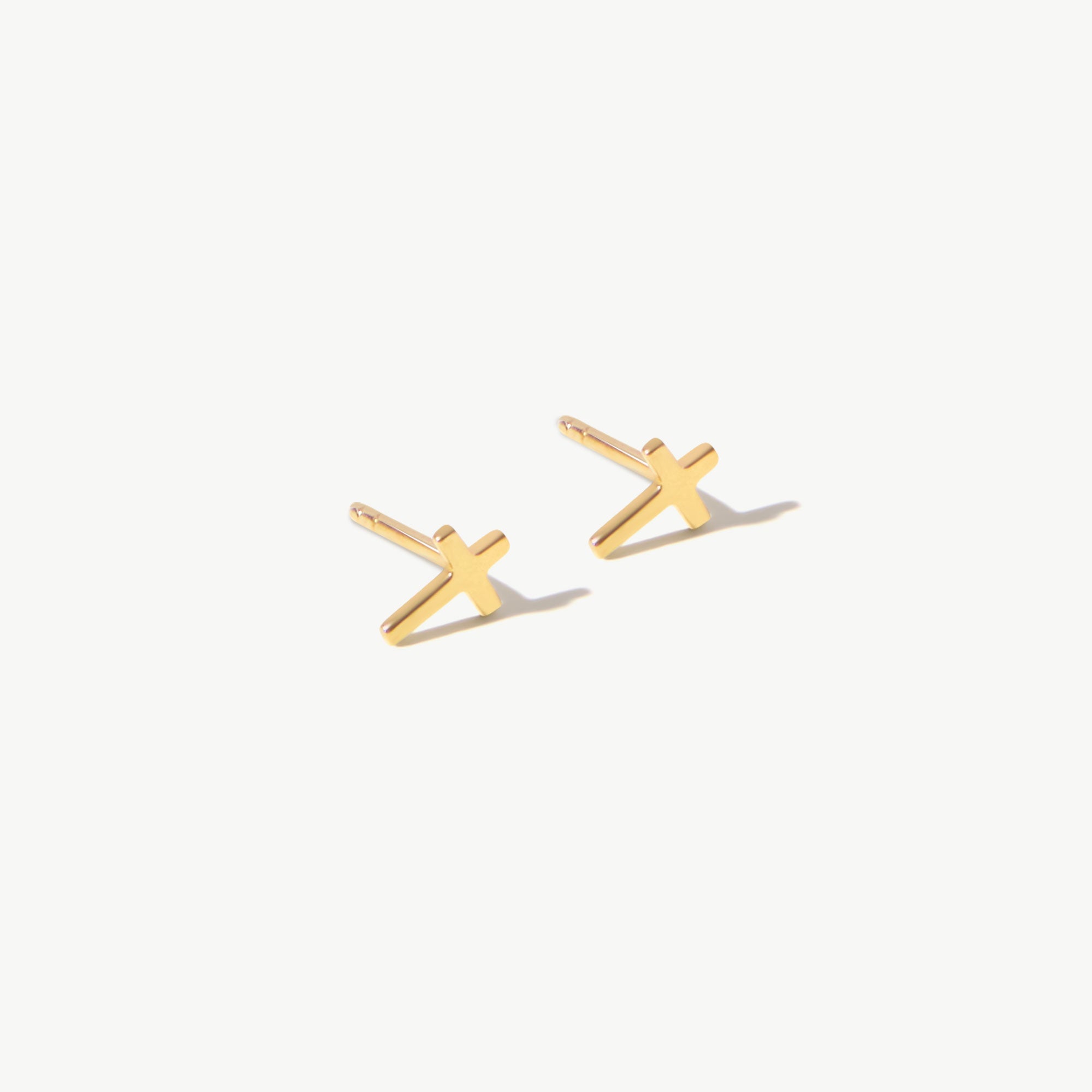 14K real solid yellow gold cross stud earrings with a minimalist design. These delicate crucifix earrings are perfect for everyday wear or as a meaningful religious gift, representing faith and protection in a sleek, modern style.