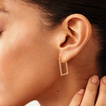Geometric 14K real solid gold hoop earrings with a rectangular design, offering a chic and minimalist look. These versatile, chunky huggie hoops elevate any look, making them ideal for daily wear or special occasions.