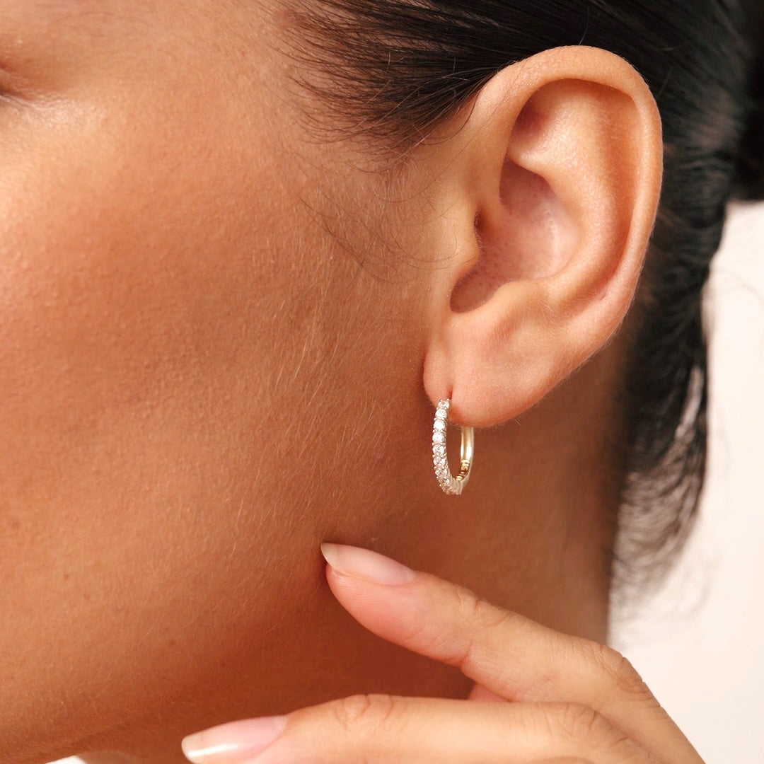 Very small 14K gold hoop earrings featuring diamond accents, combining elegance with comfort for a versatile, timeless look.