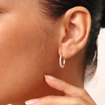 Very small 14K gold hoop earrings featuring diamond accents, combining elegance with comfort for a versatile, timeless look.