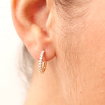 Very small 14K gold hoop earrings featuring diamond accents, combining elegance with comfort for a versatile, timeless look.