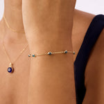A 14K Real Solid Gold London Blue Topaz Birthstone Station Bracelet featuring deep blue, faceted gemstones set along a fine gold chain, perfect for elegant wear.