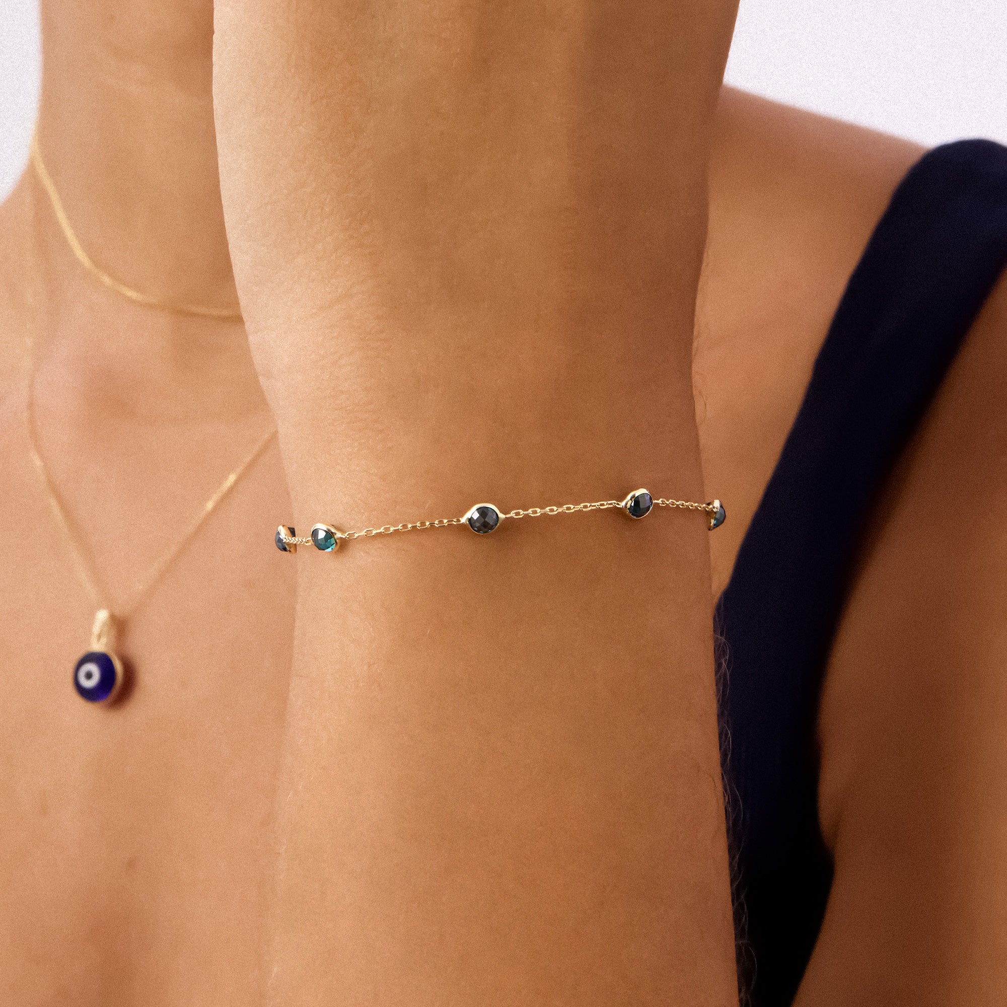 A 14K Real Solid Gold London Blue Topaz Birthstone Station Bracelet featuring deep blue, faceted gemstones set along a fine gold chain, perfect for elegant wear.