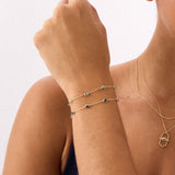 A 14K Real Solid Gold London Blue Topaz Birthstone Station Bracelet featuring deep blue, faceted gemstones set along a fine gold chain, perfect for elegant wear.
