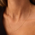 Real 14K yellow gold Cuban link chain necklace, showcasing a thin and delicate curb design. This minimalist gold chain is perfect for layering or wearing alone, offering a simple yet sophisticated style for everyday or evening wear.