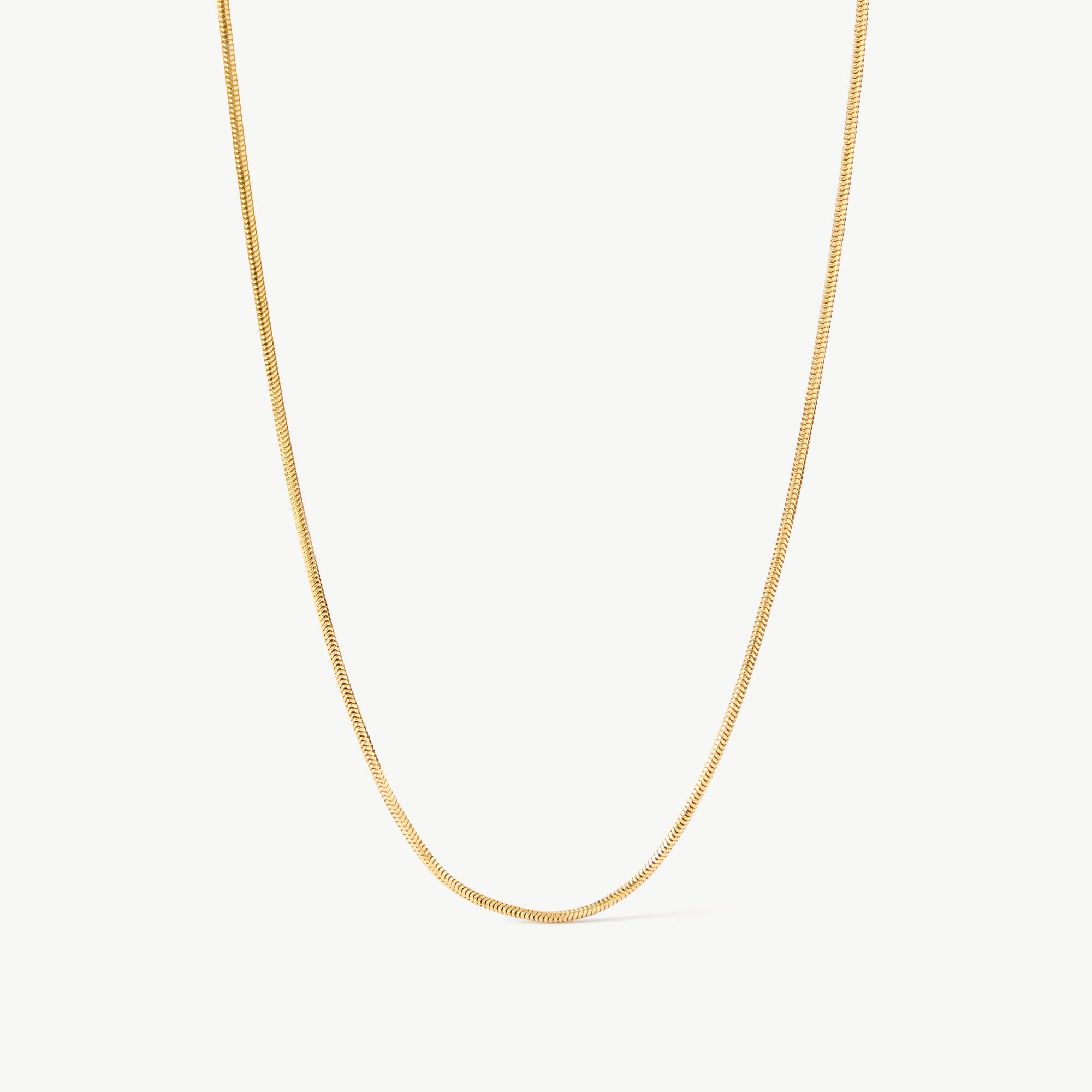 14K solid yellow gold snake chain necklace featuring a sleek, herringbone design. This minimalist and elegant chain offers a smooth, fluid texture, perfect for layering or wearing as a statement piece for everyday sophistication.