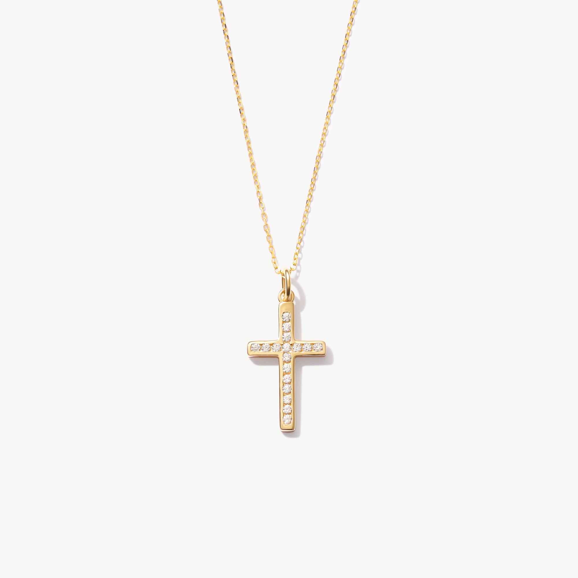 Yellow gold cross necklace with diamonds on a white background