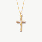 Yellow gold cross necklace with diamonds on a white background