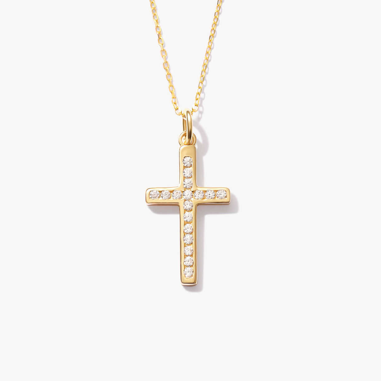 Yellow gold cross necklace with diamonds on a white background