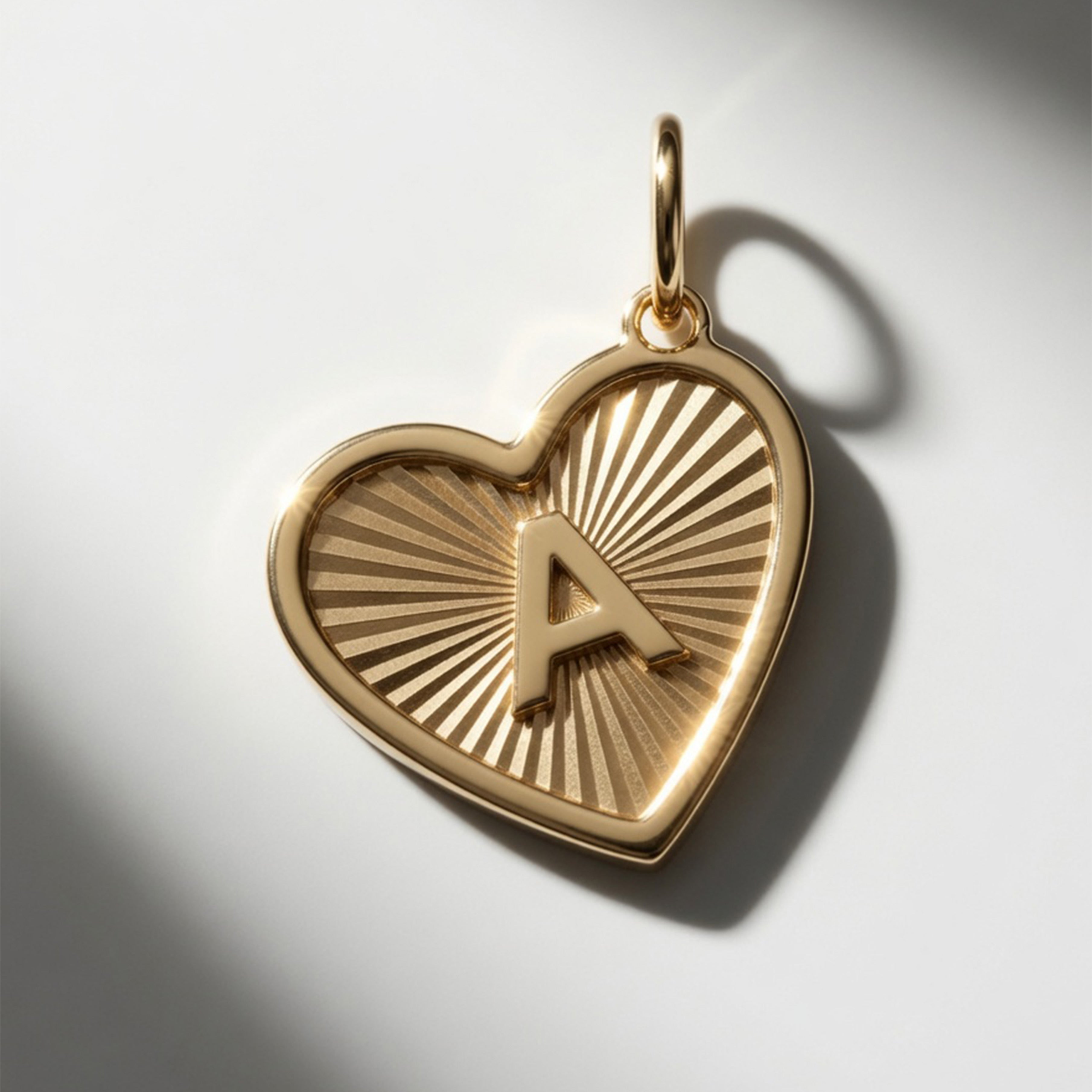 Premium 14K gold initial A heart pendant featuring 3D raised letter design and sunburst engraving.