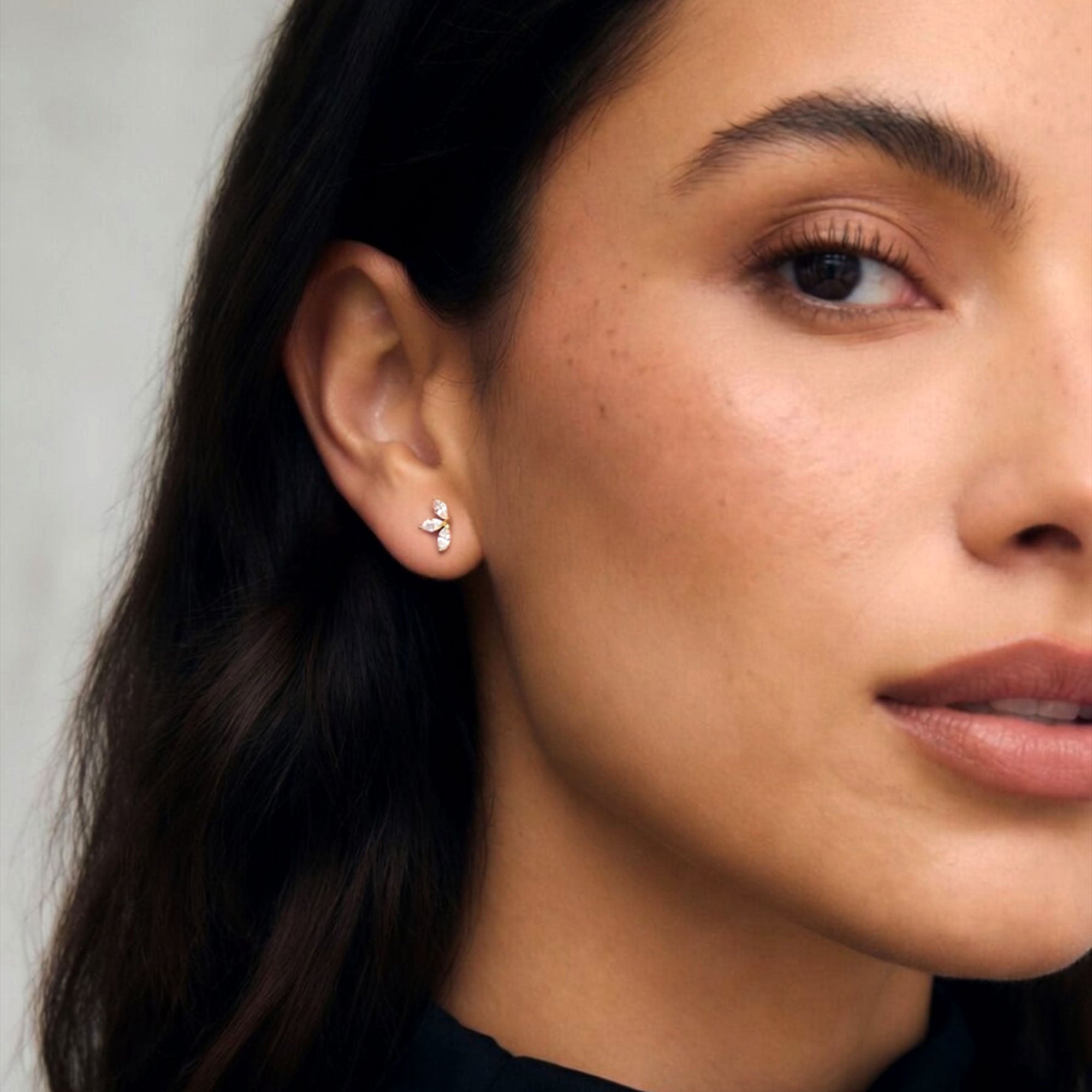 Lifestyle image featuring marquise diamond flower stud earrings worn on the ear with elegant everyday styling.