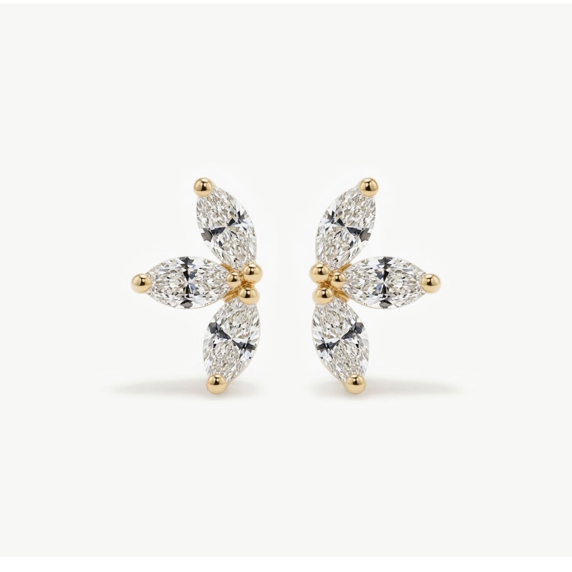 Pair of 14K solid gold floral diamond stud earrings displayed upright, highlighting the marquise diamond cluster arrangement.