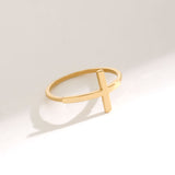 Minimalist 14K solid yellow gold cross ring with a sleek modern cross silhouette photographed on a clean white background, featuring a delicate polished band and soft natural shadow reflection.