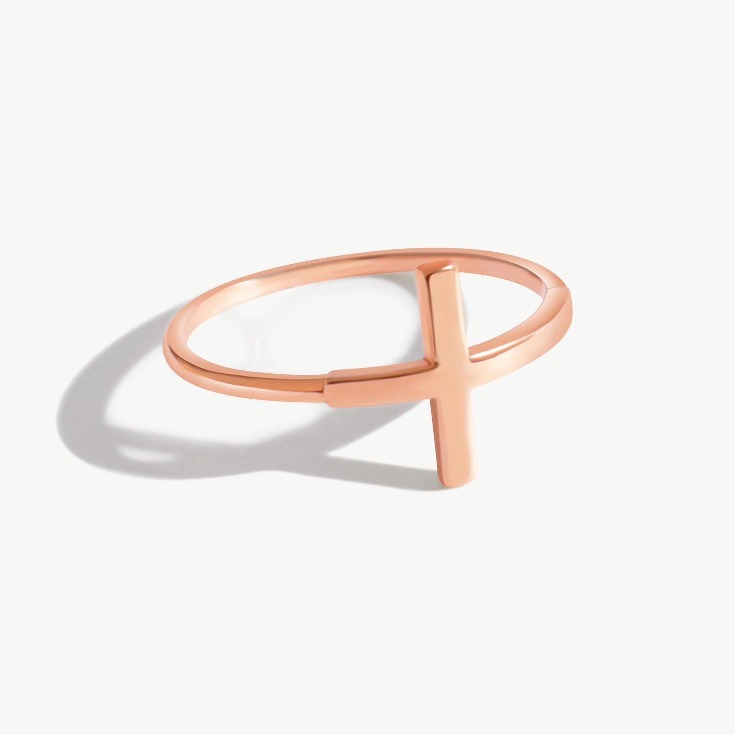 14K solid rose gold cross ring displayed on a soft neutral background with natural lighting, featuring a contemporary cross design and elegant minimalist silhouette.