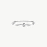Minimalist white gold birthstone ring featuring a natural diamond center stone in a polished bezel setting on a thin stackable solid gold band.