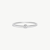 Minimalist white gold birthstone ring featuring a natural diamond center stone in a polished bezel setting on a thin stackable solid gold band.