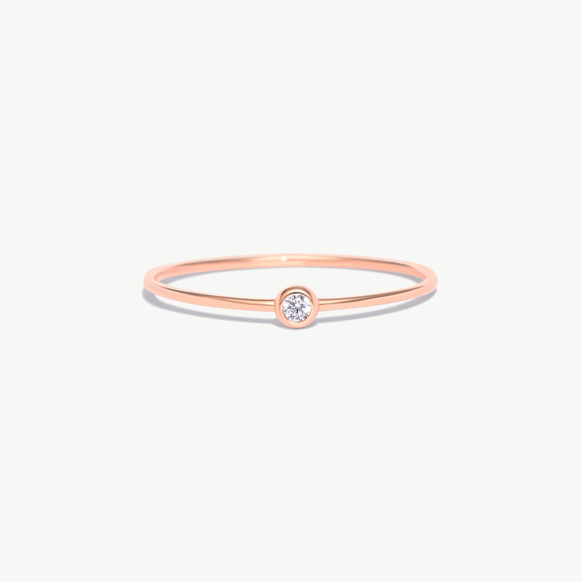 Rose gold birthstone ring featuring a natural diamond center stone in a delicate bezel setting crafted from genuine 14K solid rose gold.