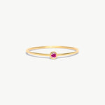 Minimalist 14K solid gold birthstone ring featuring a natural pink tourmaline gemstone in a refined bezel setting with delicate stackable thin band styling.