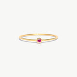 Minimalist 14K solid gold birthstone ring featuring a natural pink tourmaline gemstone in a refined bezel setting with delicate stackable thin band styling.