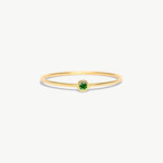 Fine jewelry product image of a minimalist natural emerald birthstone ring crafted from genuine 14K solid gold with delicate thin band proportions photographed on a white background.