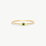 Fine jewelry product image of a minimalist natural emerald birthstone ring crafted from genuine 14K solid gold with delicate thin band proportions photographed on a white background.