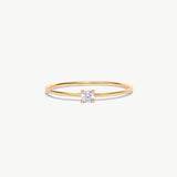 Minimalist 14K solid gold solitaire diamond ring featuring a natural round brilliant diamond in a delicate four-prong setting on a thin polished gold band photographed on a white background.