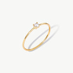 Fine jewelry product image of a dainty 14K solid gold solitaire engagement ring featuring a natural round diamond and slim minimalist band design.