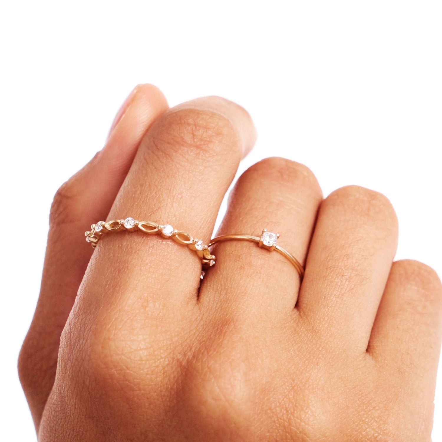 Close-up hand photograph showing a minimalist natural diamond solitaire ring paired with a delicate gold beaded stacking ring crafted from genuine 14K solid gold.
