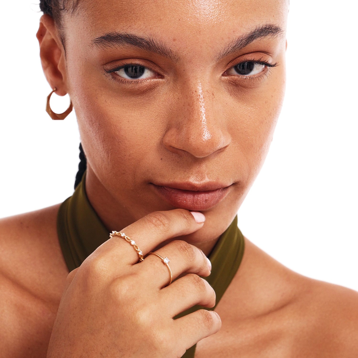 Editorial portrait of a woman wearing elegant stackable 14K solid gold rings including a natural diamond solitaire ring in refined minimalist styling.