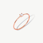 Rose gold solitaire diamond ring featuring a natural round brilliant diamond in a delicate prong setting on a thin polished rose gold band.