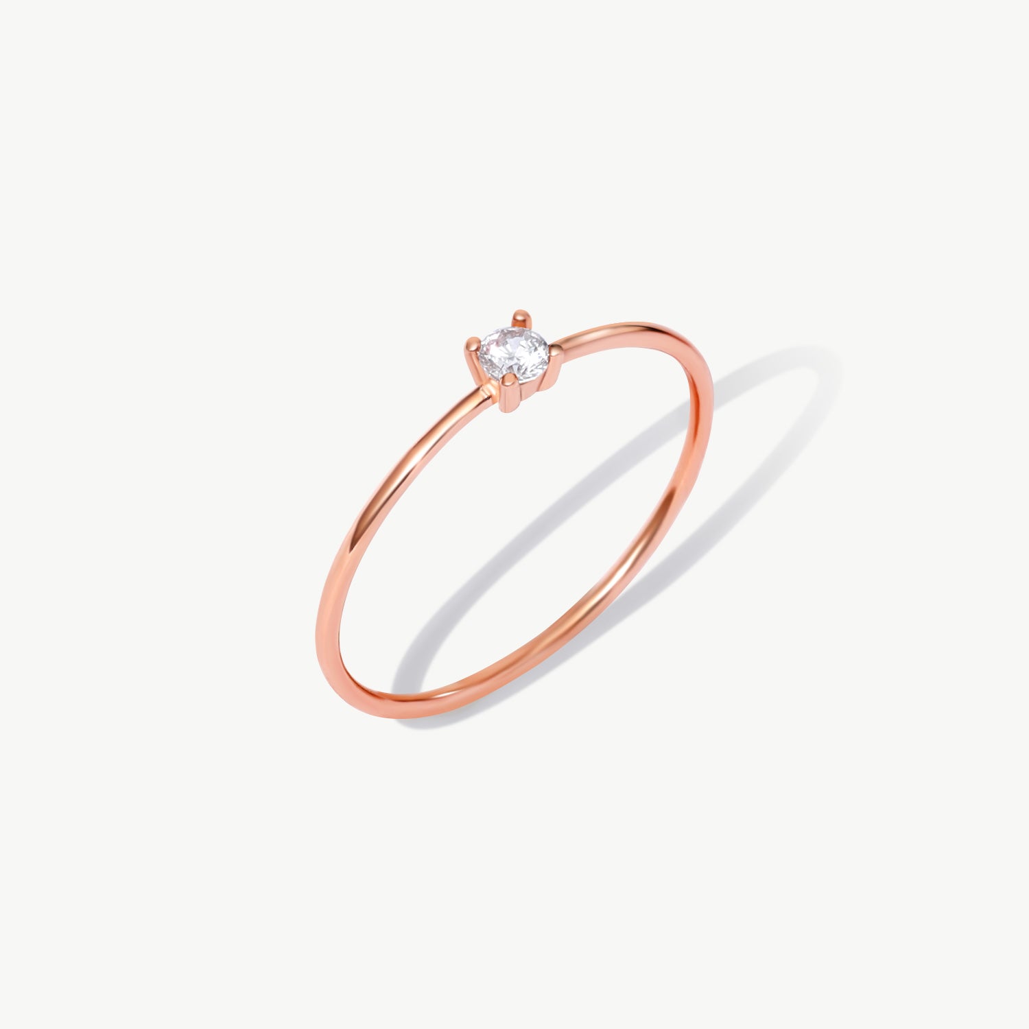 Rose gold solitaire diamond ring featuring a natural round brilliant diamond in a delicate prong setting on a thin polished rose gold band.