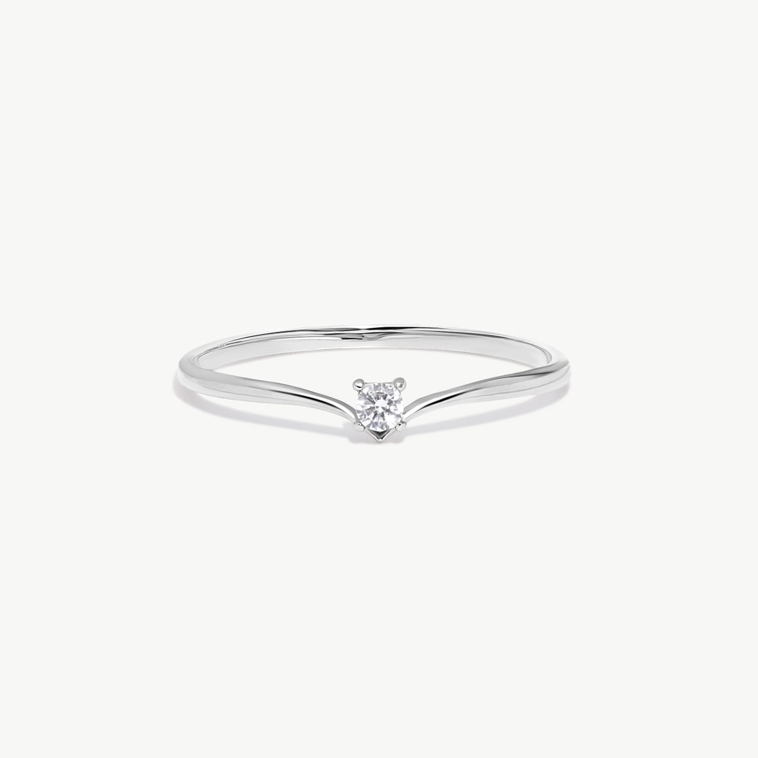 White gold wishbone solitaire ring featuring a natural round brilliant diamond in a delicate V shaped polished band photographed on a white background.