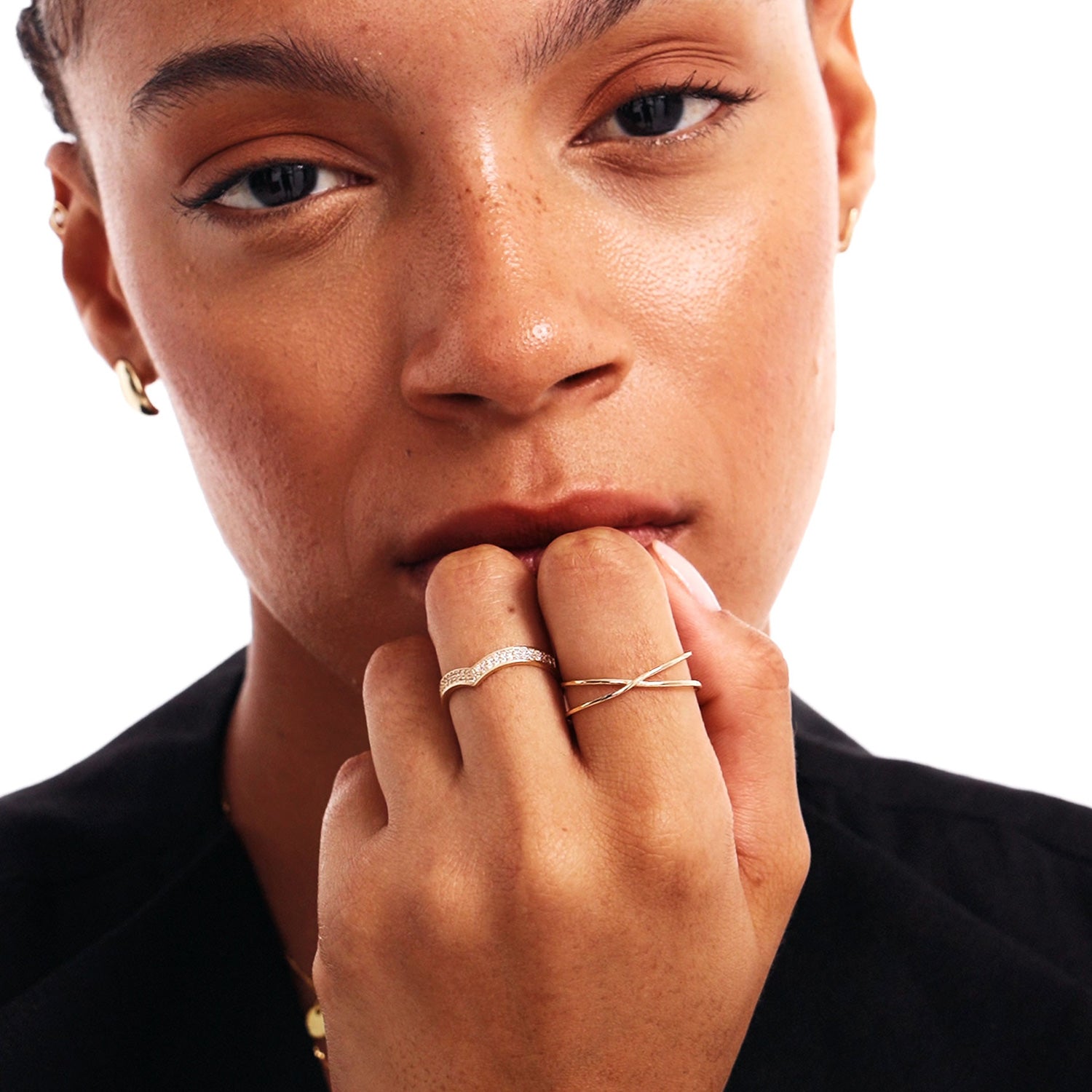 Editorial beauty portrait of a woman wearing a delicate diamond wishbone promise ring and a Minimalist Crossover Ring.