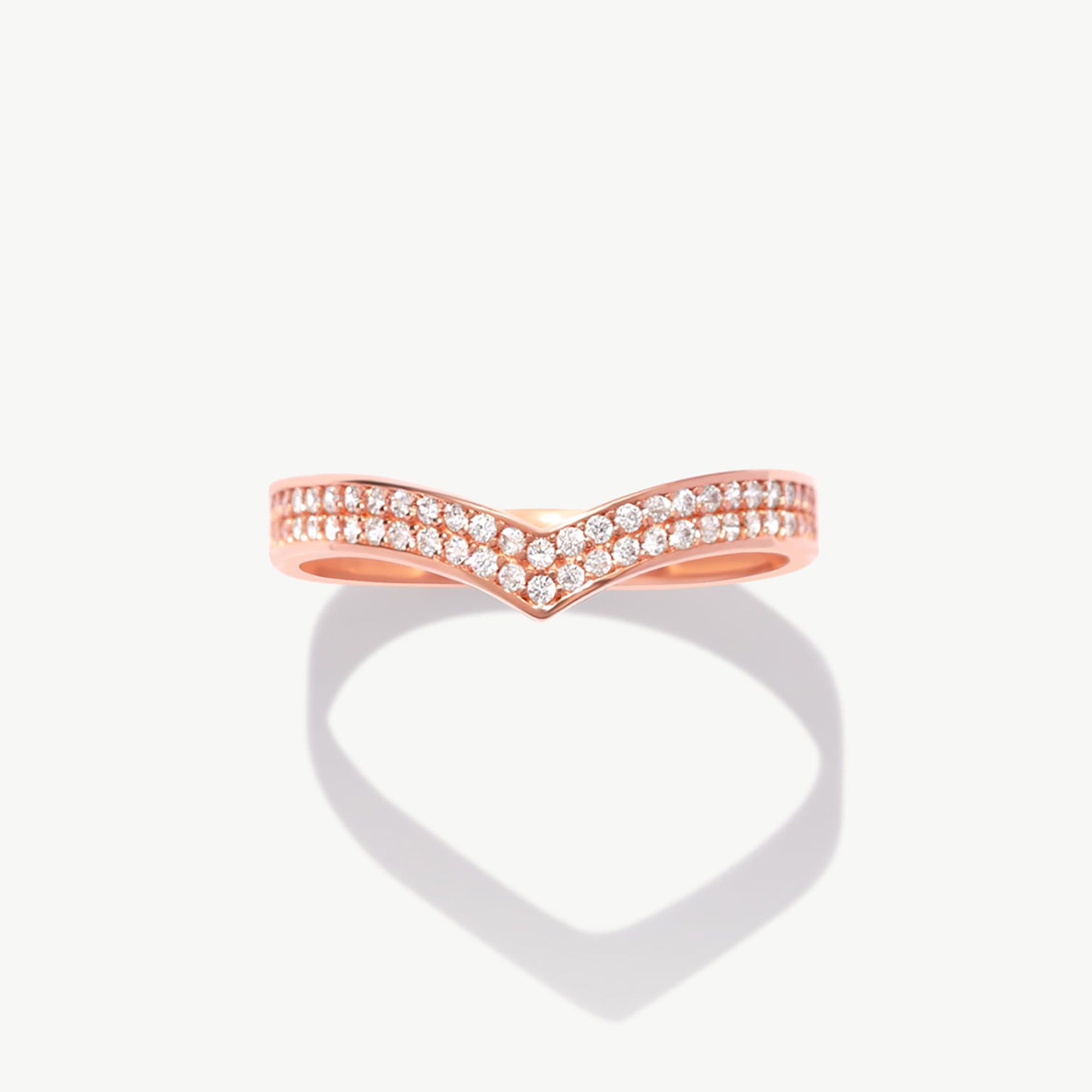 Rose gold wishbone eternity band featuring natural pavé diamonds photographed front facing with a soft heart-shaped shadow reflection.