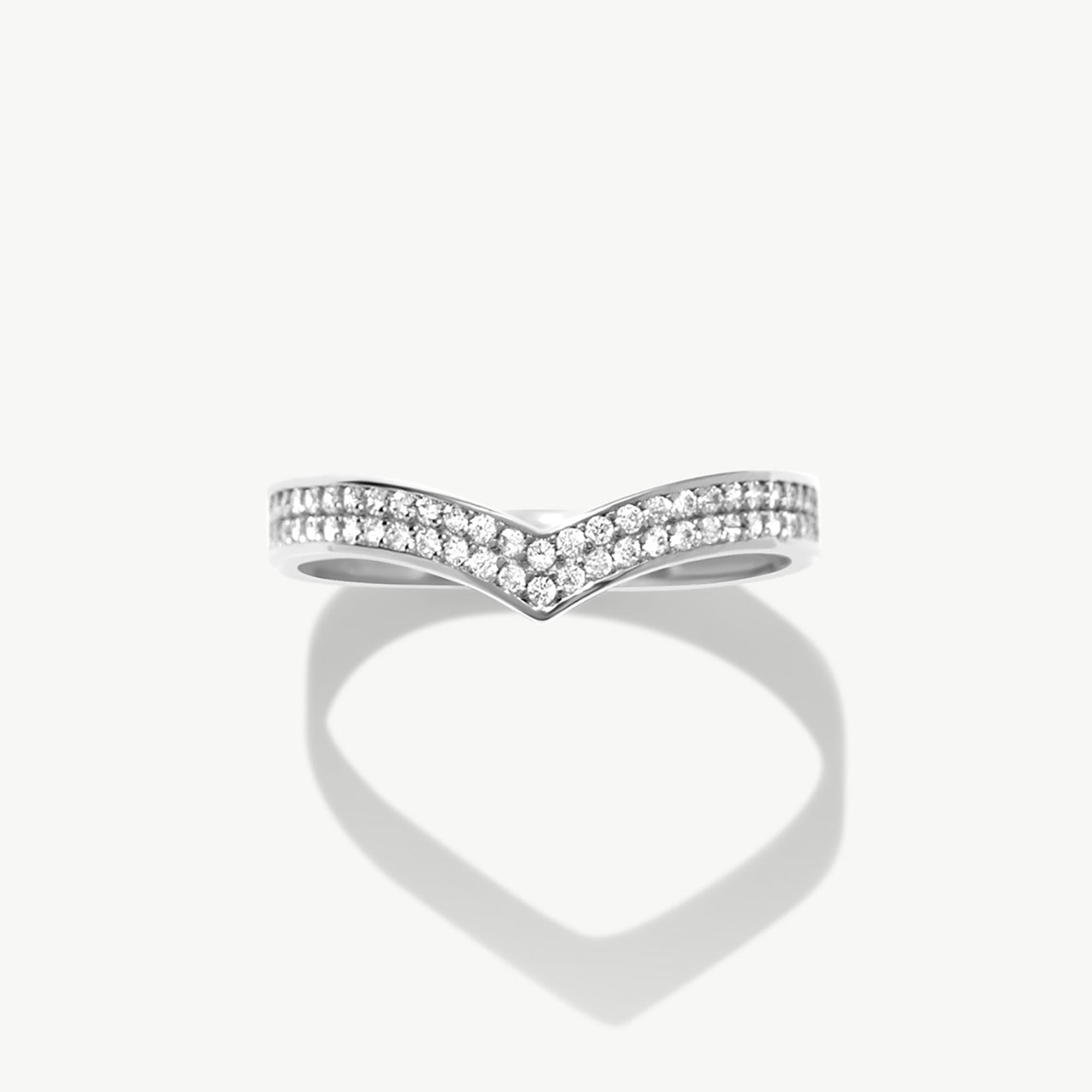 White gold diamond wishbone eternity ring photographed front facing on a white background highlighting the pavé diamond setting and V shaped silhouette.