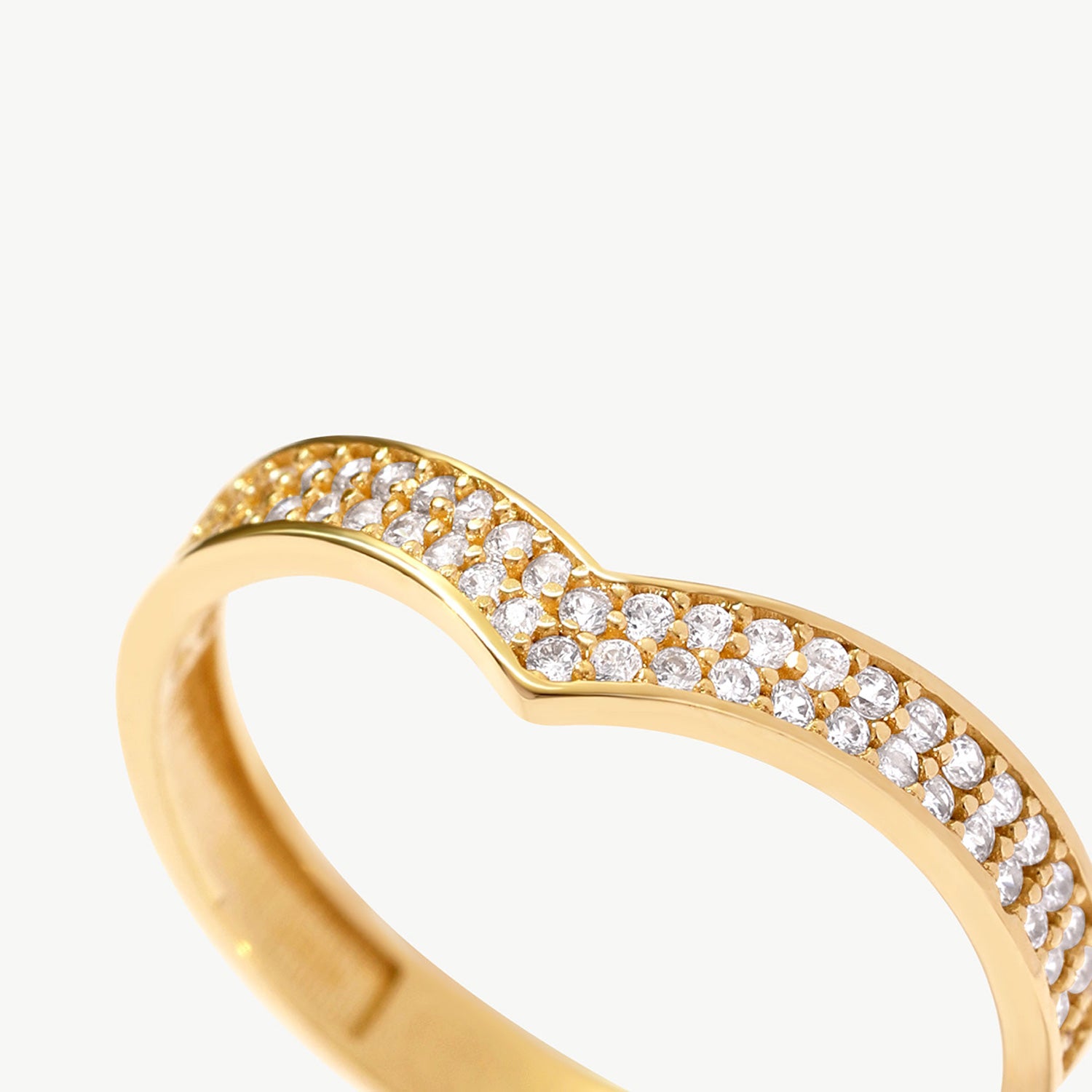 Macro jewelry photograph of a natural diamond wishbone eternity ring featuring pavé set round brilliant diamonds in a refined V shaped silhouette.