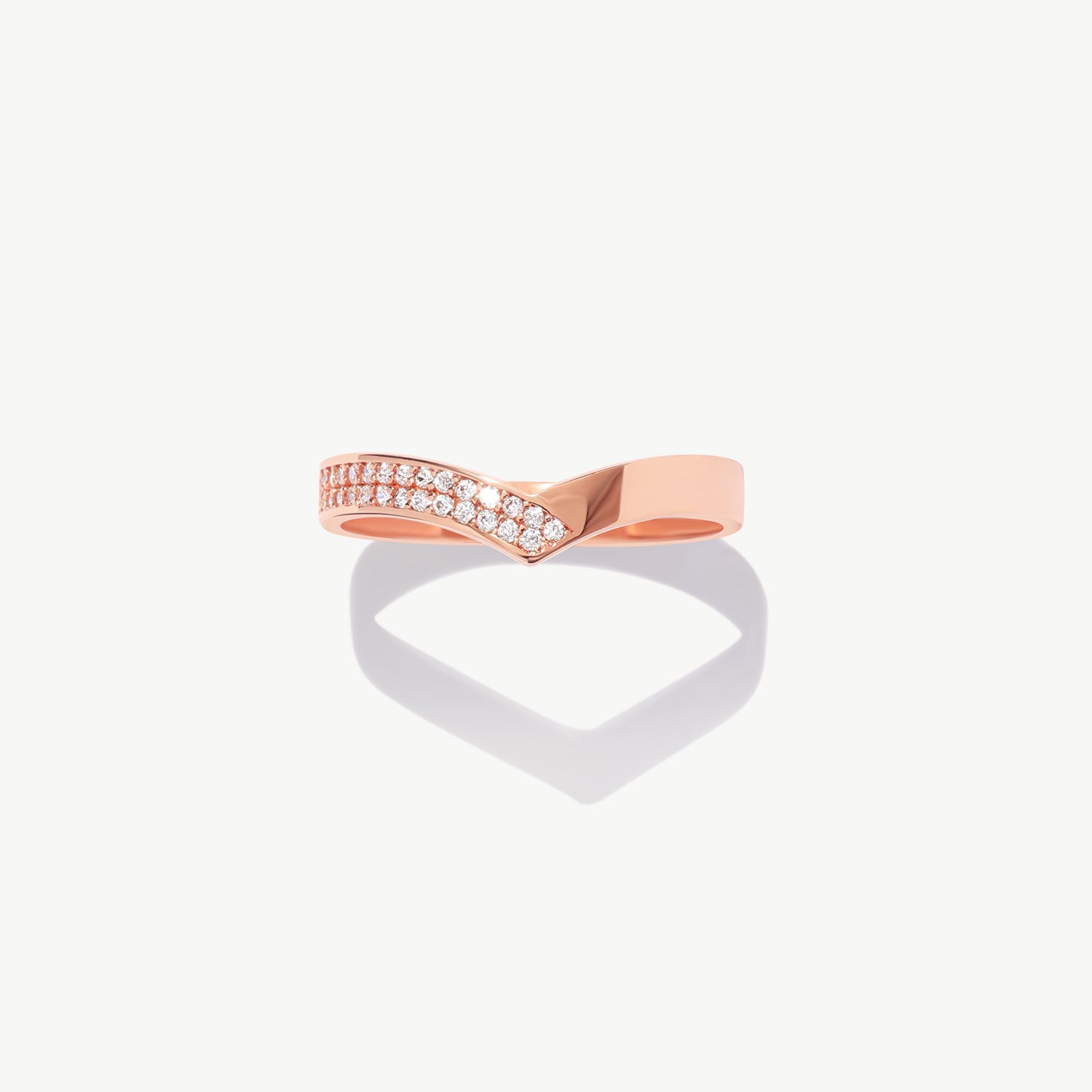 Rose gold diamond half eternity wishbone ring featuring pavé set natural diamonds photographed on a white background with a soft heart shaped shadow reflection.