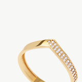 Macro jewelry photograph highlighting the pavé diamond setting and sharp V shaped silhouette of a 14K solid gold eternity band.